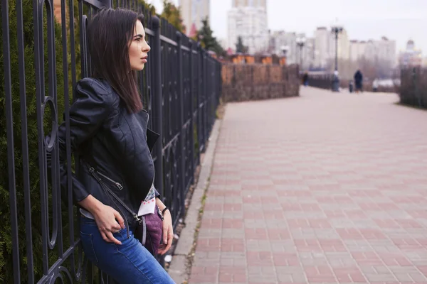 Bela mulher morena em jaqueta de couro preto andando sobre o — Fotografia de Stock