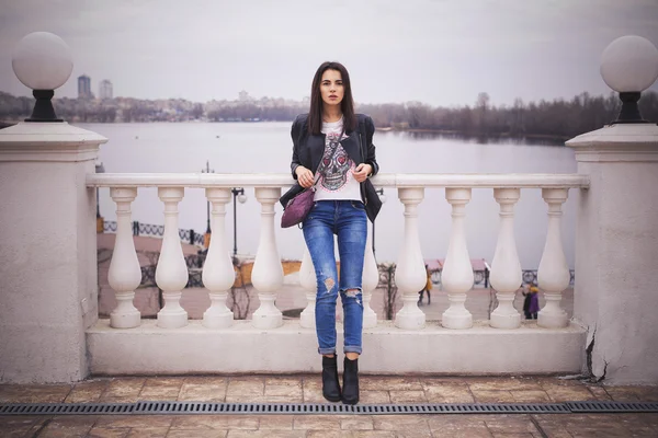 Hermosa mujer morena en chaqueta de cuero negro caminando sobre el —  Fotos de Stock