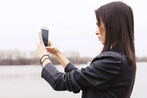 Belle femme brune sur une promenade dans la ville européenne en utilisant son sm — Photo