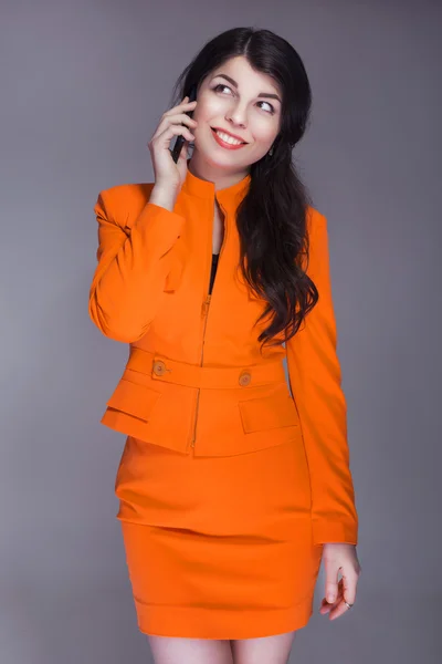 Mooie brunette Kaukasische vrouw in oranje stijlvolle buisness su — Stockfoto