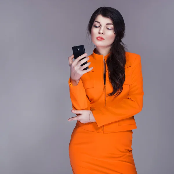 Mooie brunette Kaukasische vrouw in oranje stijlvolle buisness su — Stockfoto