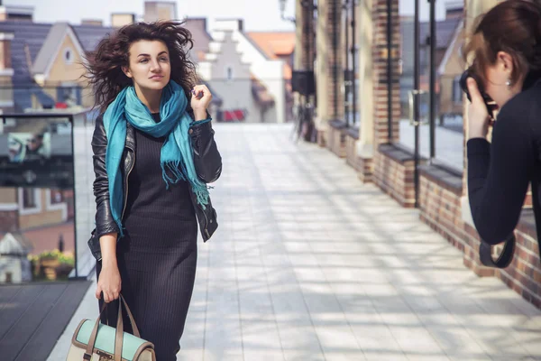 Fotograf fotografiert eine schöne brünette Frau bei einem Spaziergang auf eu — Stockfoto
