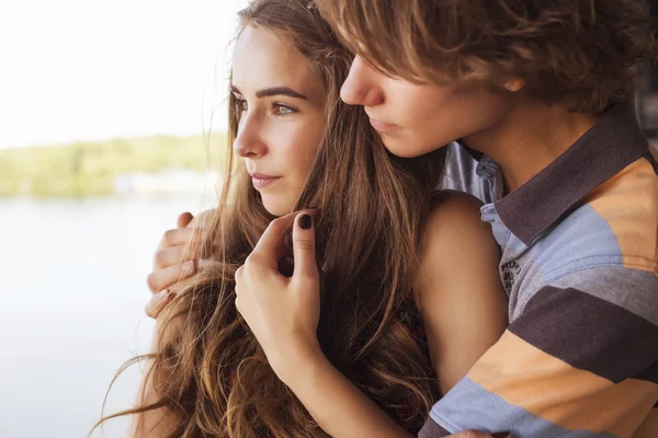 Young couple hugging in the summer daylight on a bridge construc — Stock Photo, Image