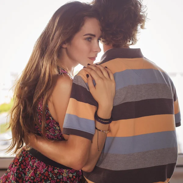 Giovane coppia che si abbraccia alla luce del giorno d'estate su un ponte costruito — Foto Stock