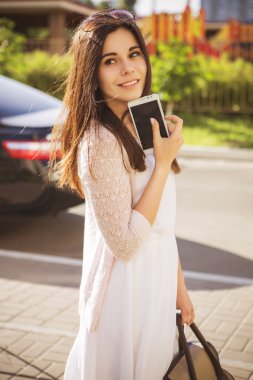 Güzel esmer beyaz genç kadın siyah arabanın yakınında duran