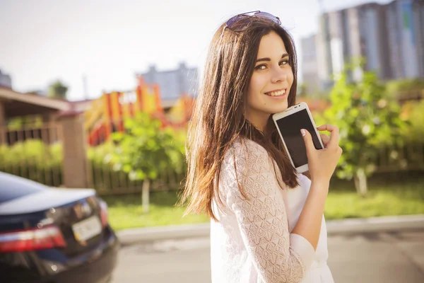 Mooie brunette Kaukasische jonge vrouw die permanent in de buurt van zwarte auto — Stockfoto