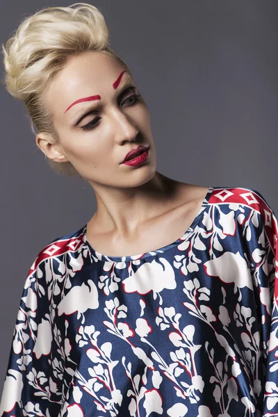 Young blonde transgender woman model in long blue pattern dress, — Stock Photo, Image