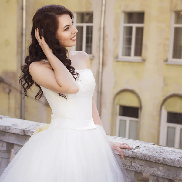 Mooie brunette vrouw bruid in een tuin park in witte bruiloft — Stockfoto