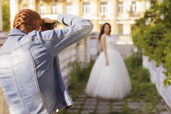 Fotograaf vastleggen een mooie brunette vrouw bruid in een garde — Stockfoto