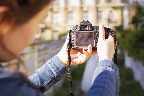 Fotograaf vastleggen een mooie brunette vrouw bruid in een tuin park in witte bruiloft jurk, krullend kapsel en een glimlach. warm weer, buitenshuis. Achter de schermen — Stockfoto