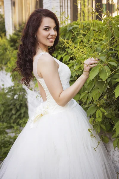 Beautiful brunette woman bride in a garden park in white wedding — Stock Photo, Image