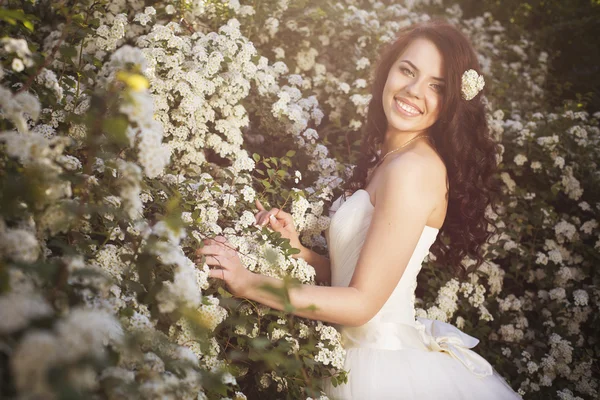 Schöne brünette Frau Braut in einem Gartenpark in weißer Hochzeit — Stockfoto