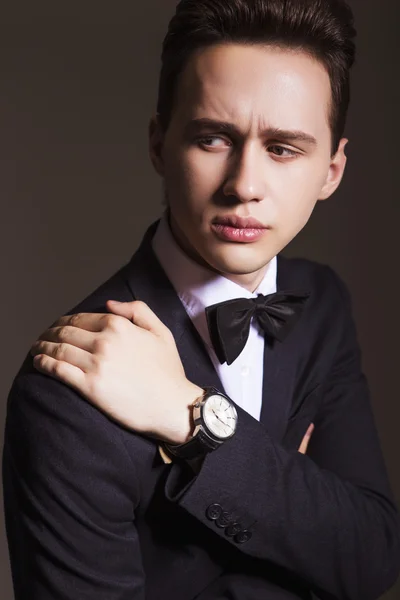 Ung vacker brunett macho affärsman i svart kostym och rosett — Stockfoto