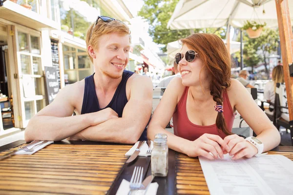 Jovem casal bonito gengibre na luz do dia de verão comendo no c — Fotografia de Stock