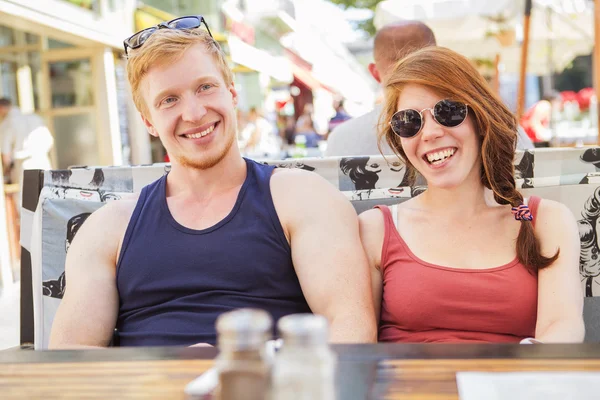 Jovem casal bonito gengibre na luz do dia de verão comendo no c — Fotografia de Stock