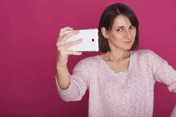 Bella bruna giovane donna in maglione rosa sorridente e holdi — Foto Stock