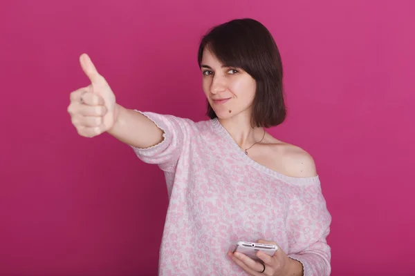 Vacker brunett ung kvinna i rosa tröja leende och kvadraterna — Stockfoto