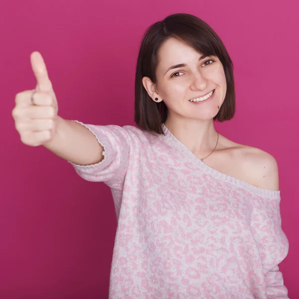 Piękna brunetka młoda kobieta w różowy sweter uśmiechnięty i showi — Zdjęcie stockowe