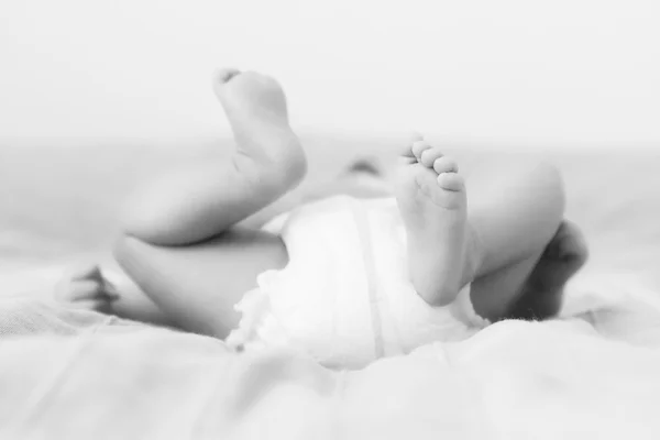 Small little newborn baby lying on her back naked in diaper with — Stock Photo, Image