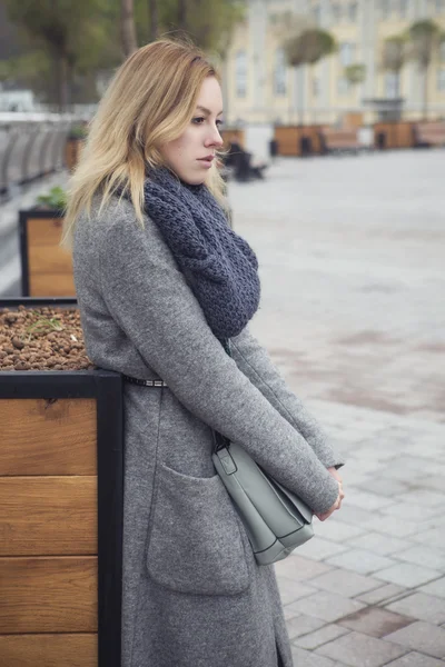 Vacker blond ung kaukasisk kvinna i grå kappa och halsduk wa — Stockfoto