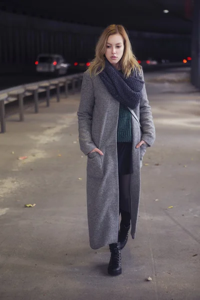 Beautiful blonde woman in long grey warm coat, skirt, boots and — Stock Photo, Image