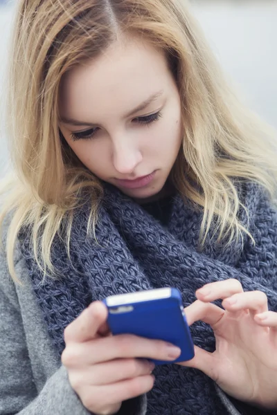 Beautiful blonde woman on a walk in european city using her smar — Stock Photo, Image