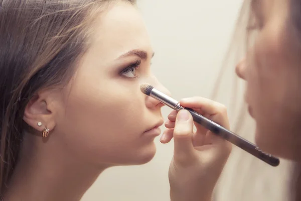 Brunette make-up artiest vrouw toepassing maken omhoog voor een brunette br — Stockfoto