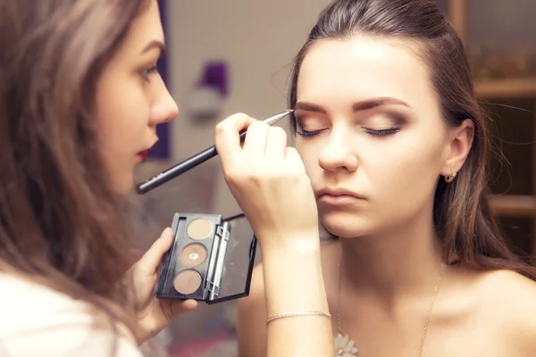 Brunette make-up artiest vrouw toepassing maken omhoog voor een brunette br — Stockfoto