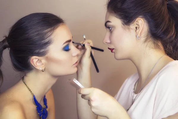 Brunette make up artist woman applying make up for a brunette mo — Stock Photo, Image