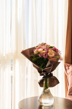 Odadaki masanın üzerinde bir vazo çiçek var.