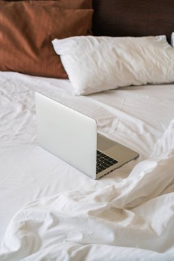 Yatağın üzerinde açık bir laptop var.