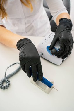 Eldivenli kadın elleri manikür yapıyor.