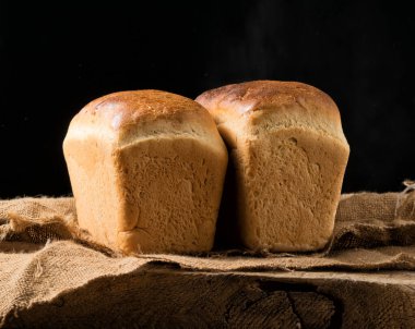 Meşe ağacının üzerinde iki somun beyaz ekmek.