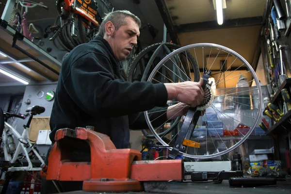 Чоловік ремонтує велосипед — стокове фото