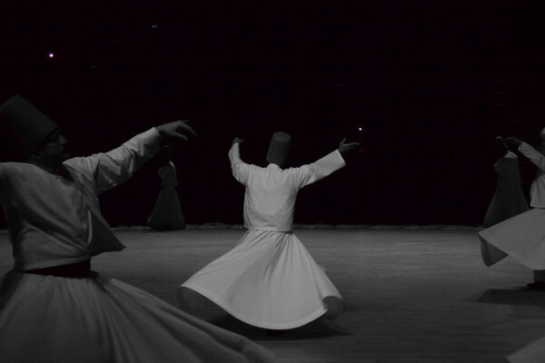 Dervishes perform on the stage for Mevlana