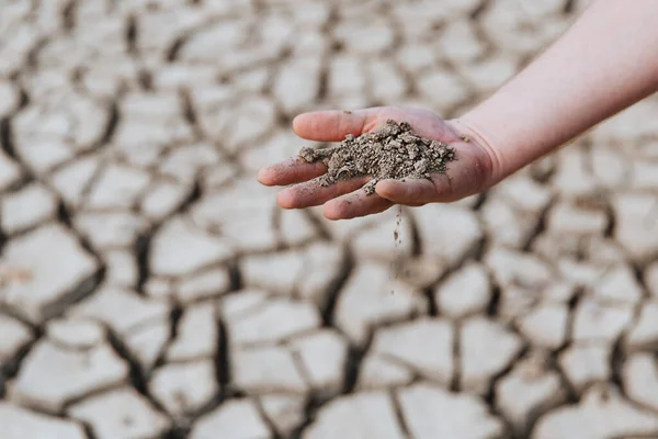 Dry earth lies in the palm of a mans hand. Warming on the plate. Water crisis. — Stock Photo, Image