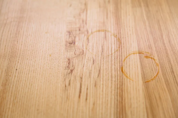 Két nedves ujjlenyomat egy csésze kávé alól egy fa asztalon.. — Stock Fotó