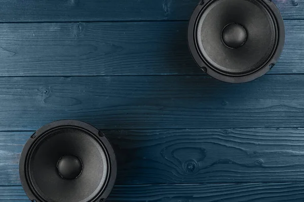Car audio, car speakers lie on a blue wooden background