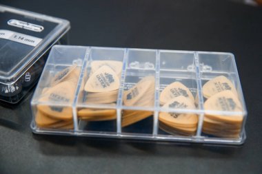 Zaporozhye, Ukrayna - 14.03.2020 Gitar çalmak için sarı seçmeler şeffaf bir kapta.
