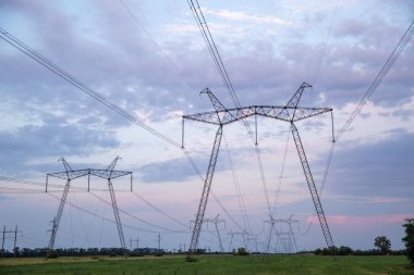 Gün batımında yüksek voltajlı elektrik hatları. Yüksek voltajlı elektrik iletim kulesi. 