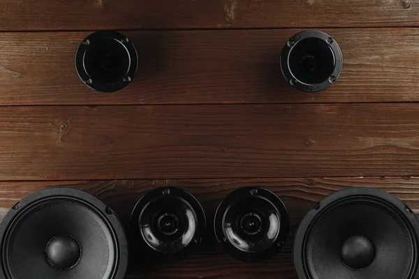 Auto audio, zwarte auto luidsprekers liggen op een bruine houten achtergrond — Stockfoto