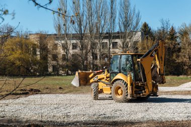 Dneprorudnoe, Ukrayna - 08 Nisan 2020: Bir traktör kovadan çakıl döktü