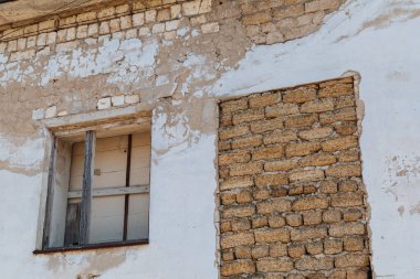 Tahta pencereli ve tuğlalı terk edilmiş bir evin eski duvarı.