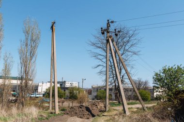 Yazlık bir köyün arka planına karşı elektrik hattı için somut bir destek