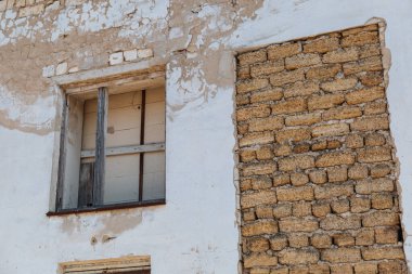 Tahta pencereli ve tuğlalı terk edilmiş bir evin eski duvarı..
