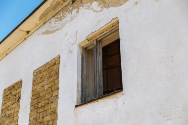 Tahta pencereli ve tuğlalı terk edilmiş bir evin eski duvarı..