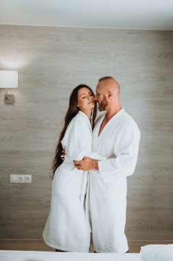 Beyaz cüppeli mutlu çift, bir kadını yanağından öpen adam.