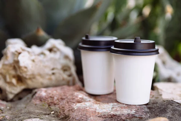 Deux tasses de café à emporter, tasses en papier blanc sur les pierres. — Photo