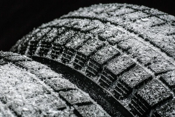 ブラックを背景に雪のクローズアップホイールプロファイル構造を持つ冬の車のタイヤ — ストック写真