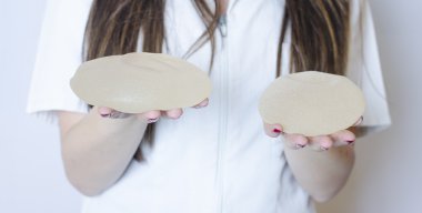 Silikon meme implantları. İmplantlar tutan hemşire. Holding doktor implantları. Plastik cerrahi